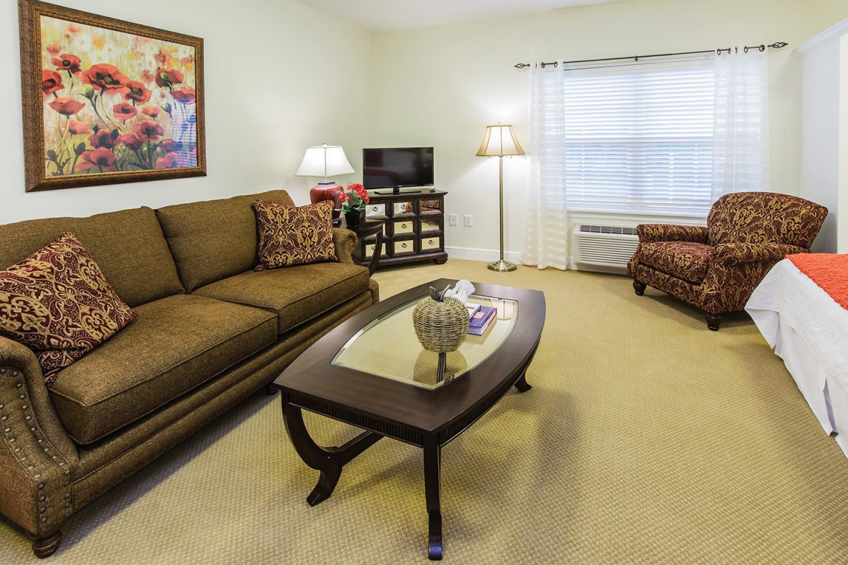 A cozy living room with a sofa, coffee table, and television.