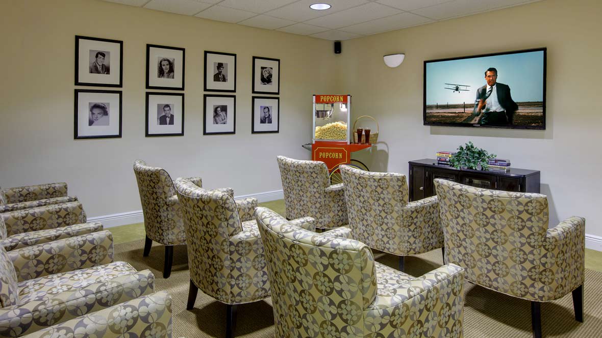 Cozy seating area with patterned chairs, a television, and a popcorn machine.