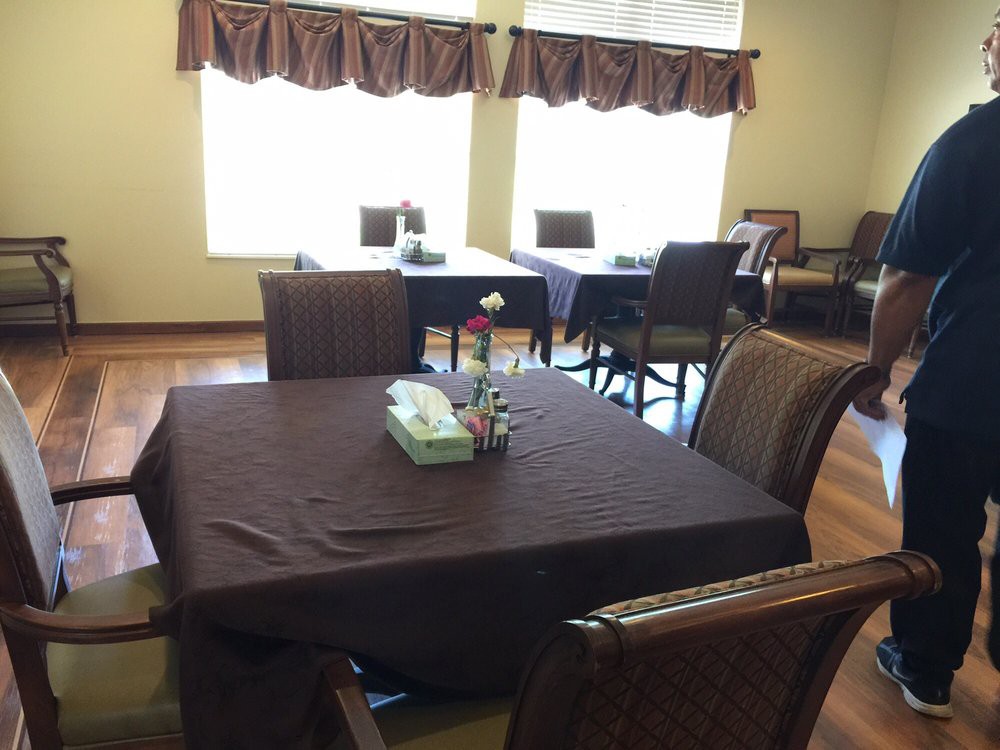 A cozy dining area with tables and chairs, decorated with curtains and a window view.