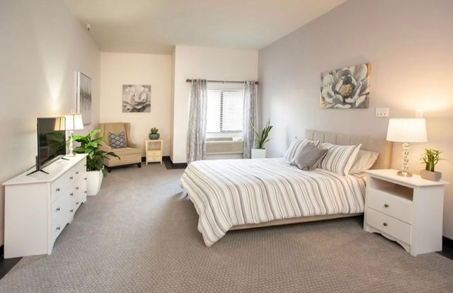 A modern, minimalist bedroom with neutral colors and cozy decor.