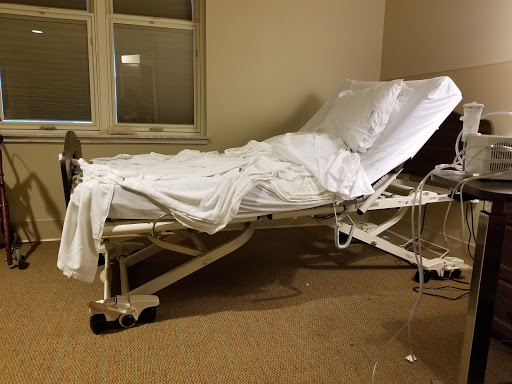 An empty hospital bed in a patient room, ready for use.