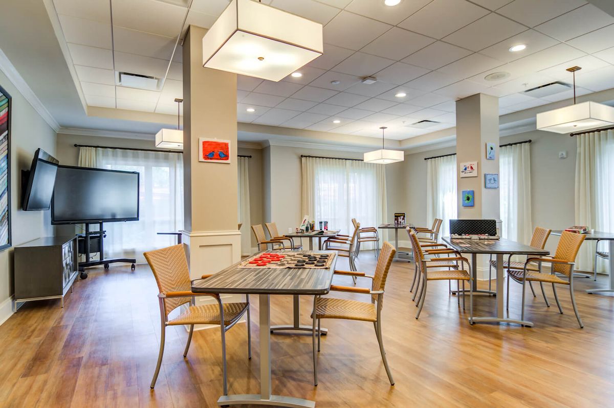 A modern dining area with tables and chairs, featuring elegant lighting.
