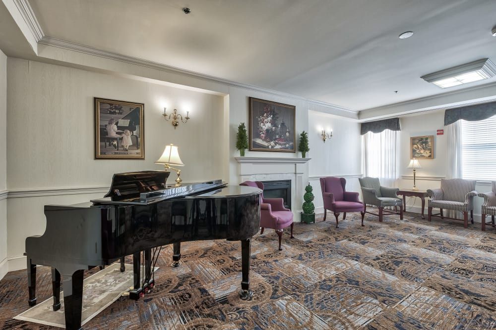 Elegant lounge area featuring a grand piano, comfortable seating, and tasteful artwork.