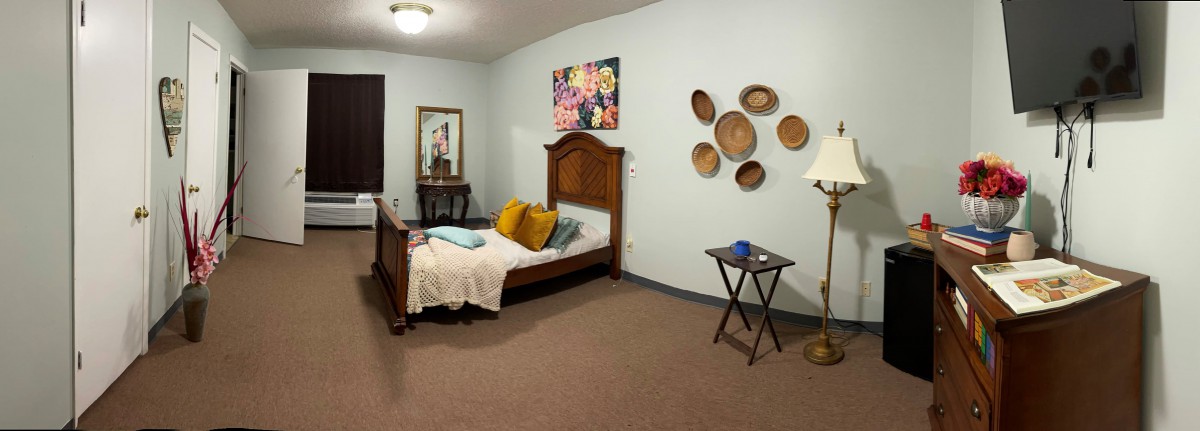 Cozy bedroom with decorative wall art and wooden furniture.
