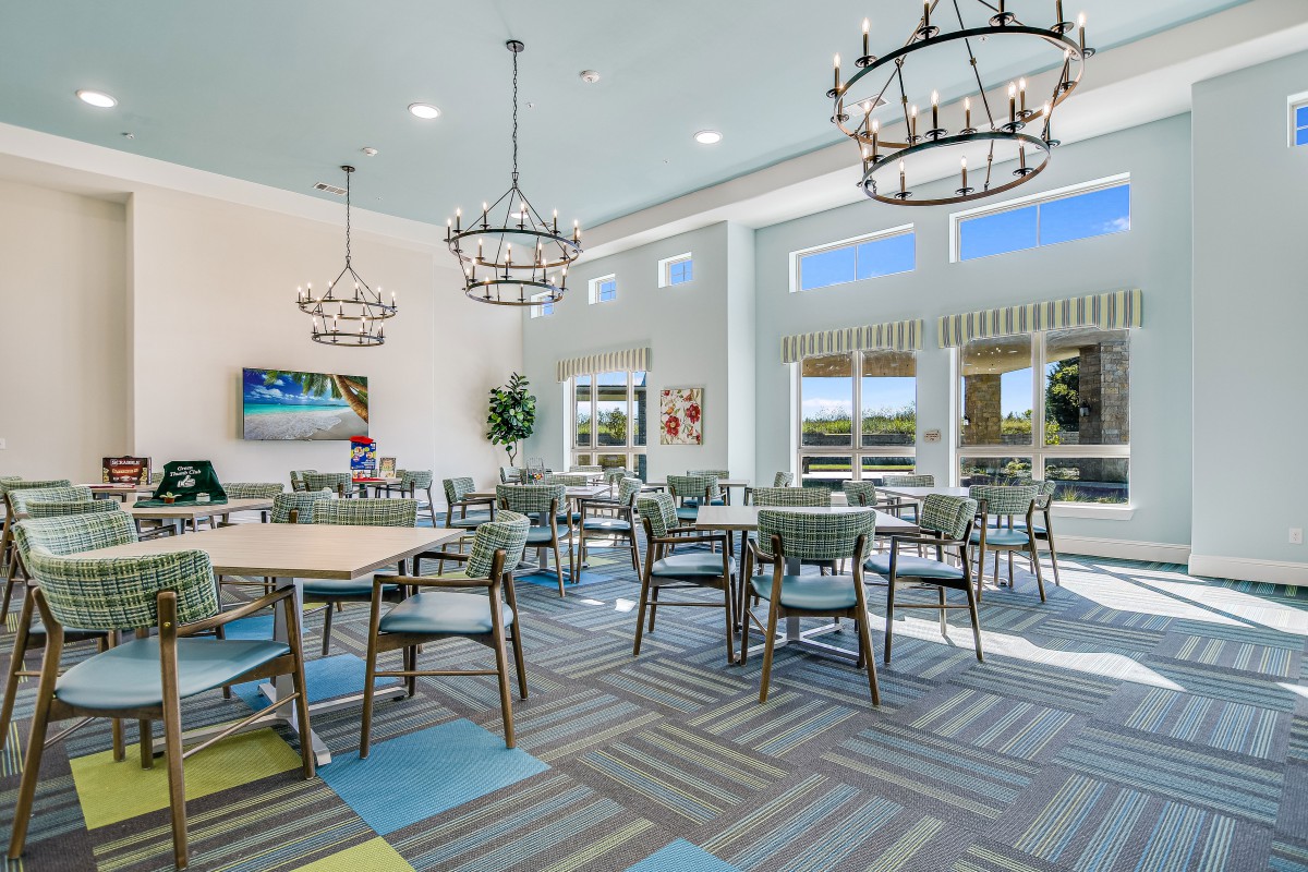 A modern dining area with elegant chandeliers and large windows providing ample natural light.