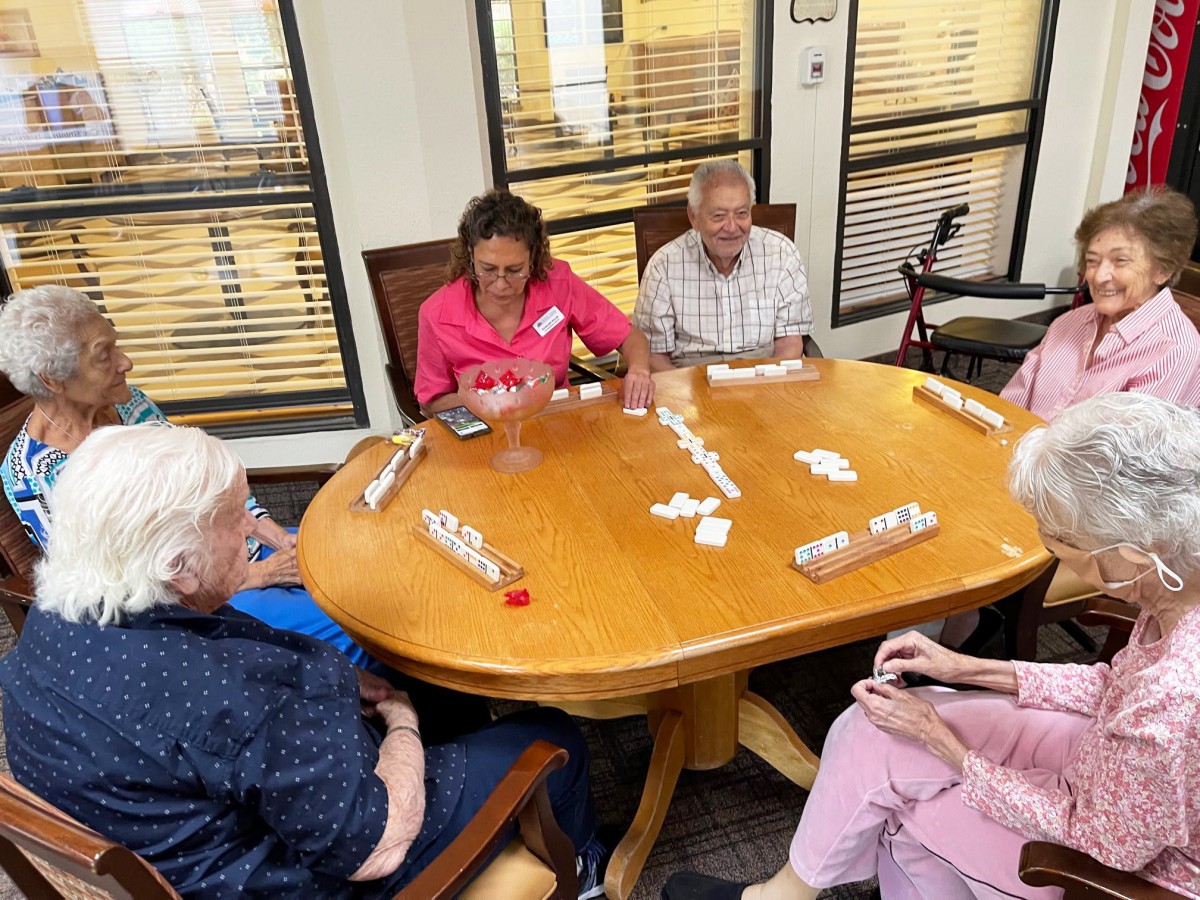 A group of seniors enjoying a card game together indoors.