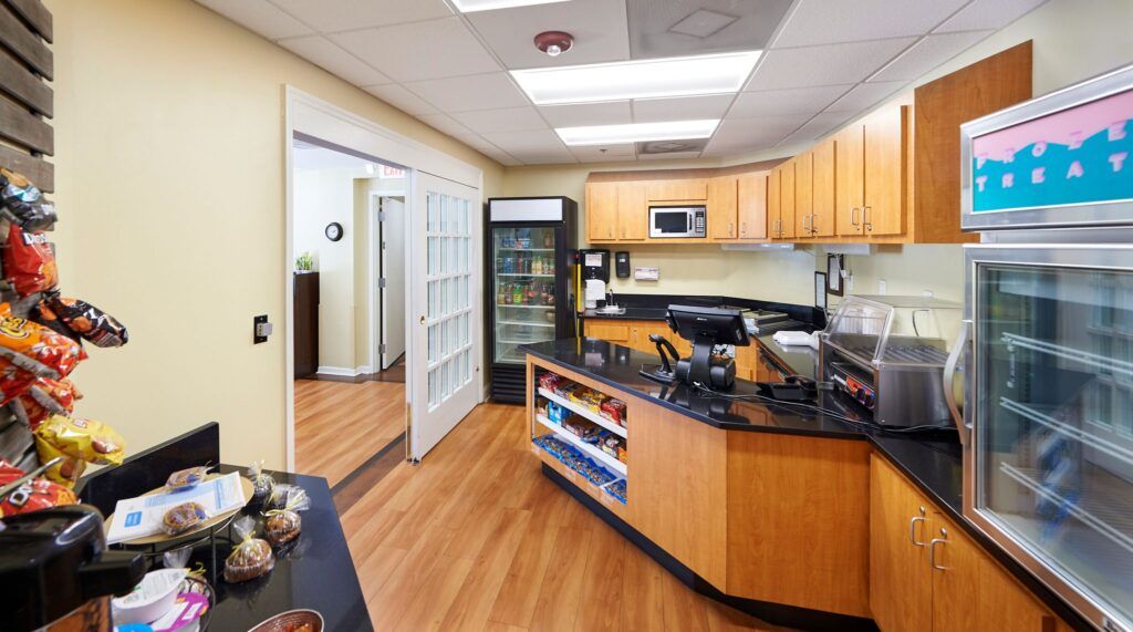 A modern office reception area featuring a wooden desk and shelves, with visible office equipment.