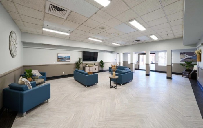 A spacious and modern lobby featuring comfortable sofas, a large television, and stylish decor.