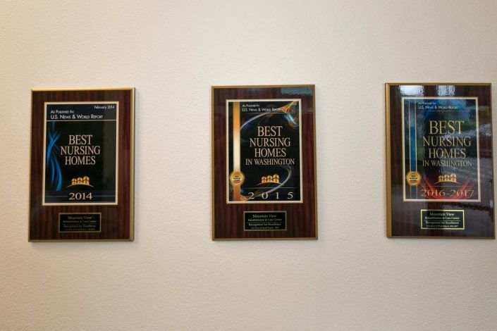 A series of award plaques displayed on a wall.
