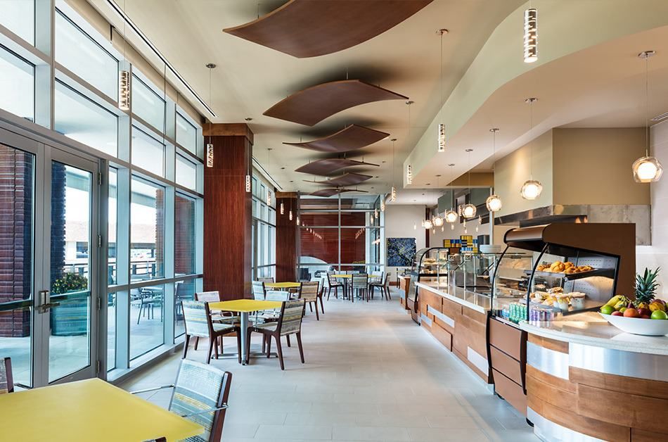 A modern cafe interior with tables and a serving counter.