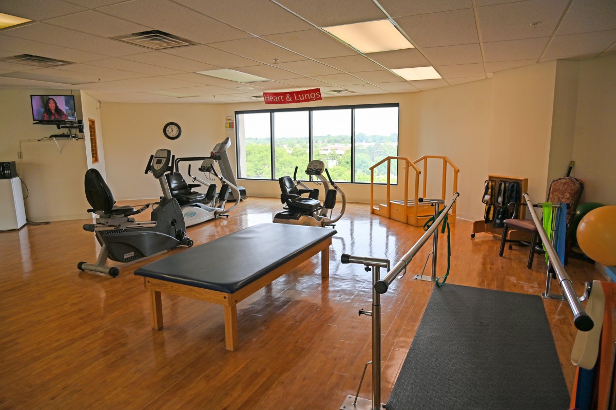 A physical therapy room equipped with various exercise machines and rehabilitation equipment.