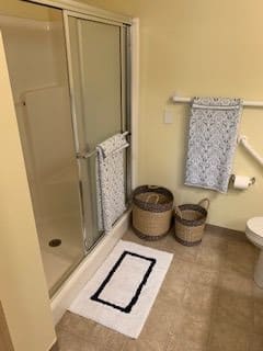 A tidy bathroom with a shower, towels, and storage baskets.