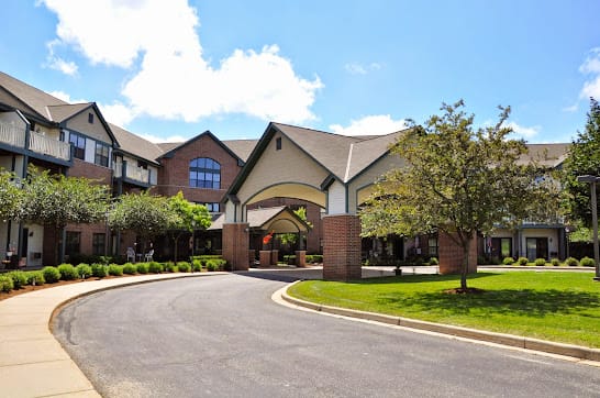 A modern building entrance with a circular driveway on a sunny day.