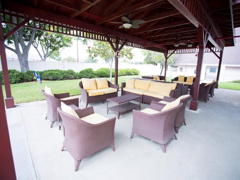 A cozy outdoor seating area with wicker furniture under a covered gazebo.