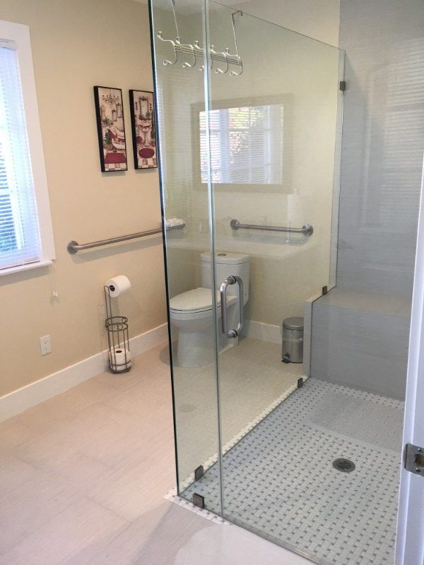 A modern bathroom featuring a glass-enclosed shower and accessible features.