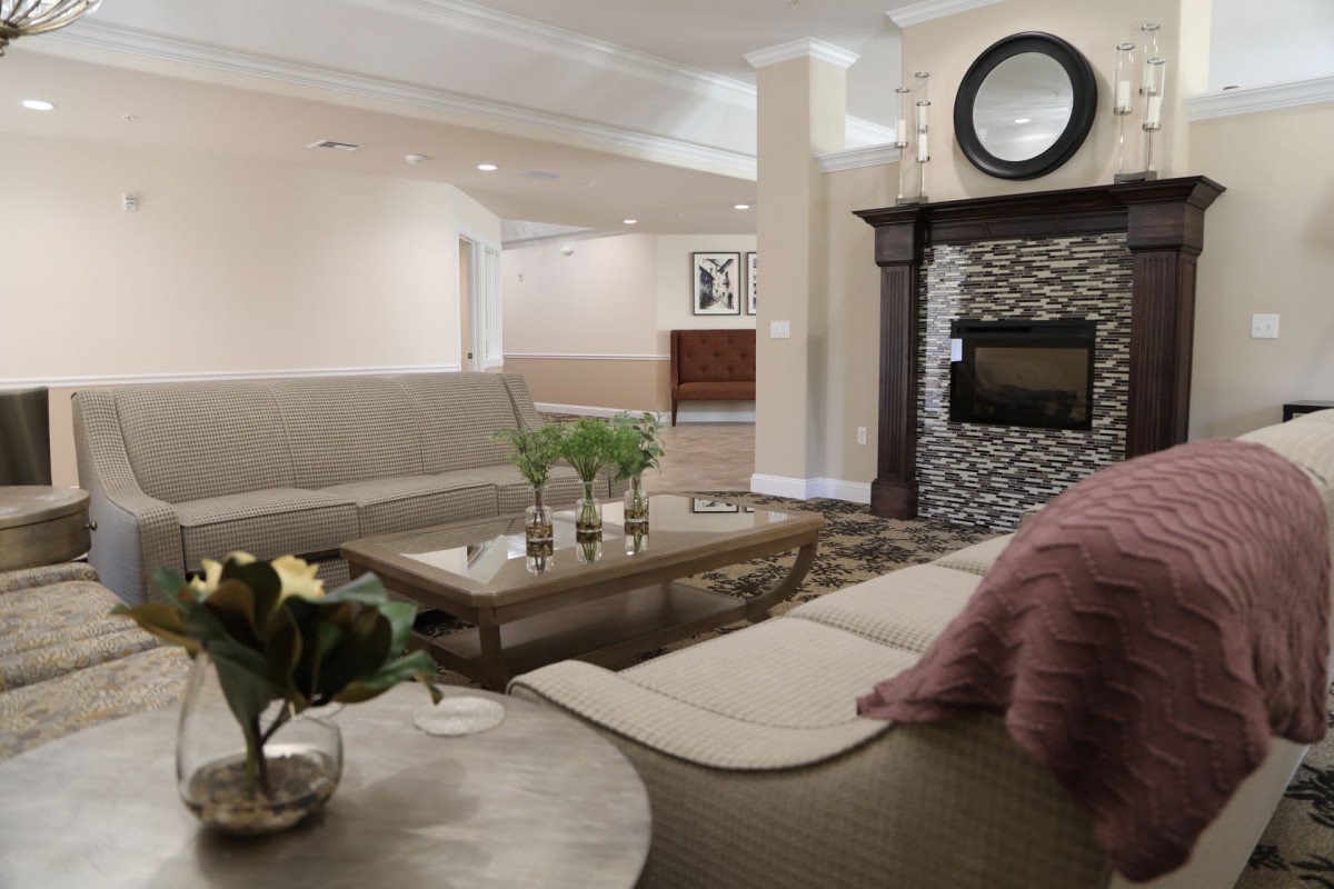 A cozy living room with modern furniture and a stone fireplace.