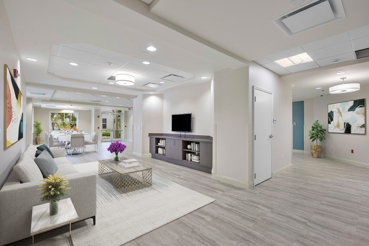 A modern, minimalist living room interior with a sofa, television, and coffee table.