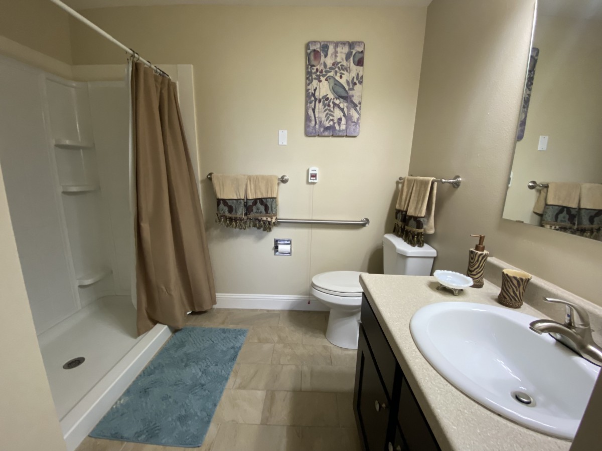 A well-organized bathroom with a shower, sink, and toilet.