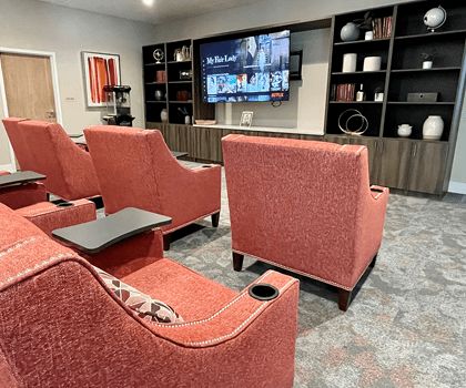 Cozy home theater setup with red chairs and a large screen TV.