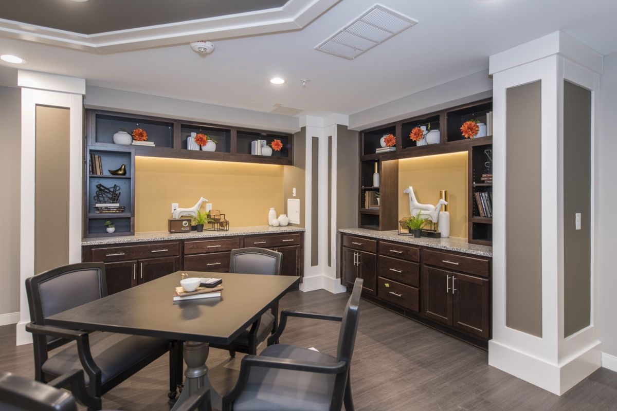 A modern conference room with sleek cabinets, a central table, and stylish decor.