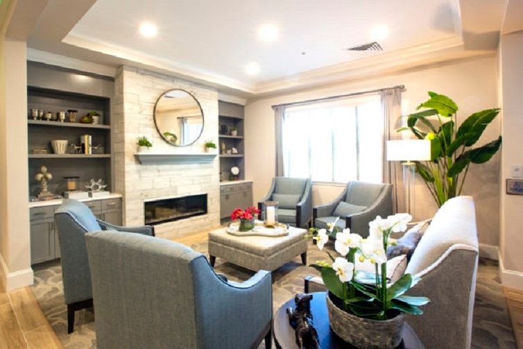 A modern living room featuring a cozy seating area with armchairs, a fireplace, and elegant decor.