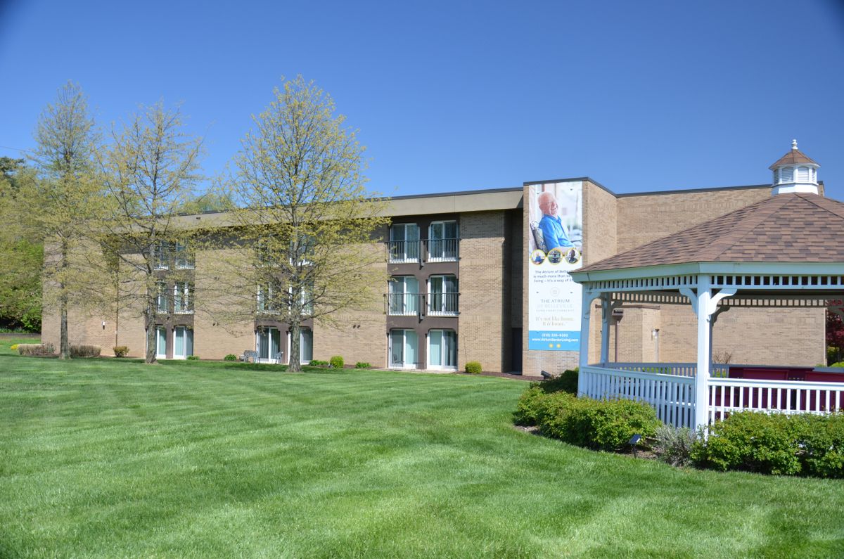 A college building with a well-maintained lawn and a gazebo.