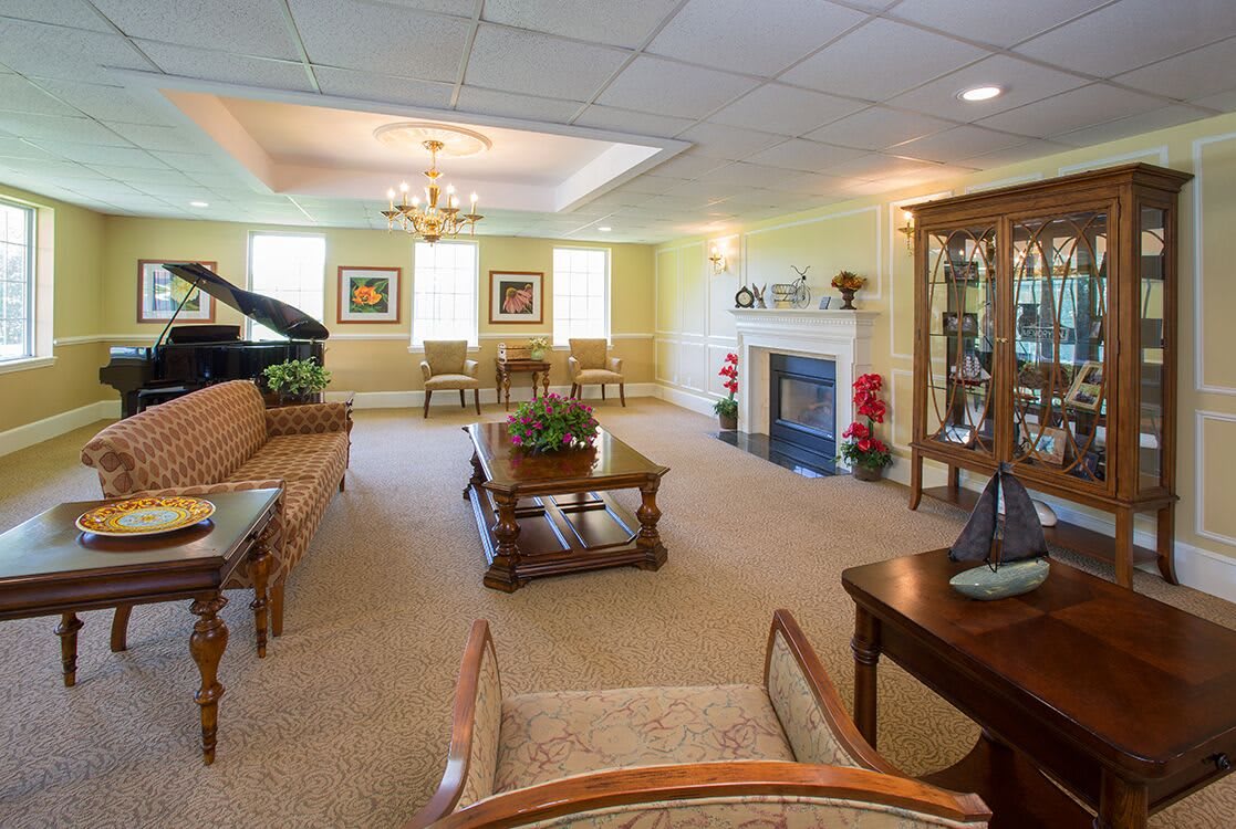 A spacious living room with elegant furnishings and a grand piano.