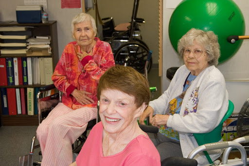 A cheerful gathering of elderly women in a care facility, enjoying each other's company.