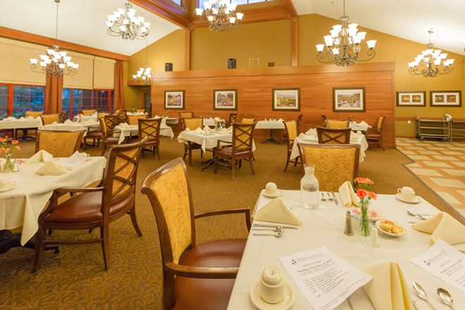 Elegant dining room with neatly set tables and warm lighting.