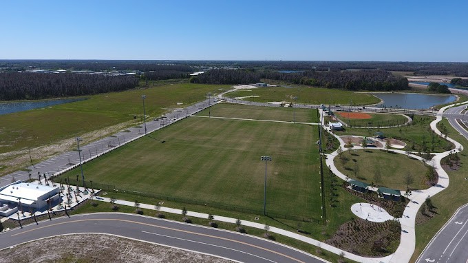 Aerial view of an empty sports field under a clear blue sky.