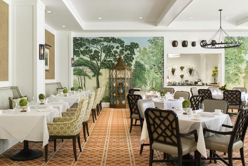 Elegant restaurant interior with a mural and neatly arranged dining tables.
