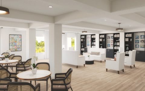 A modern living room with stylish furniture, bookshelves, and ample natural light.
