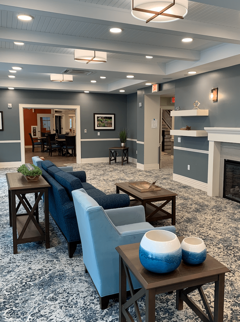 A modern living room with blue walls, comfortable seating, and a cozy fireplace.