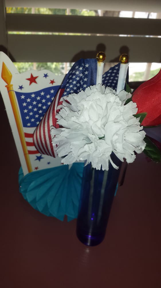 A festive arrangement featuring American flags and decorative flowers.