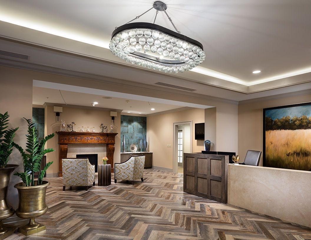 A modern lobby with elegant furnishings and a large chandelier.