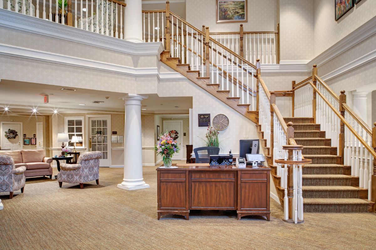 A welcoming reception area with a wooden desk and elegant staircase.