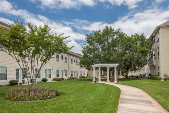 A scenic outdoor view featuring a building, lush green lawn, and a charming gazebo.