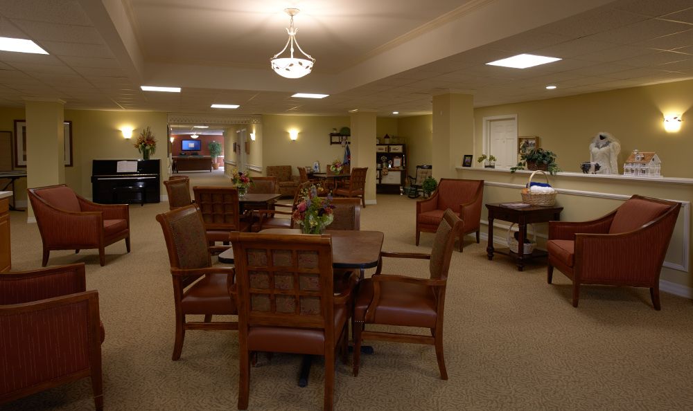 A cozy dining area with multiple tables and chairs, softly illuminated by ceiling lights.