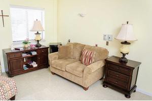 A cozy living room corner featuring a beige sofa and elegant wooden furniture.