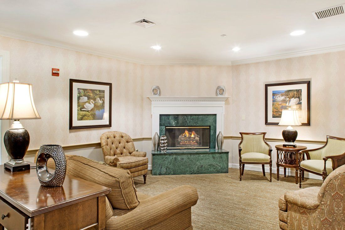 A cozy living room with a fireplace, comfortable seating, and artwork on the walls.