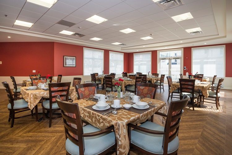 A neatly arranged dining room with tables set for a meal.