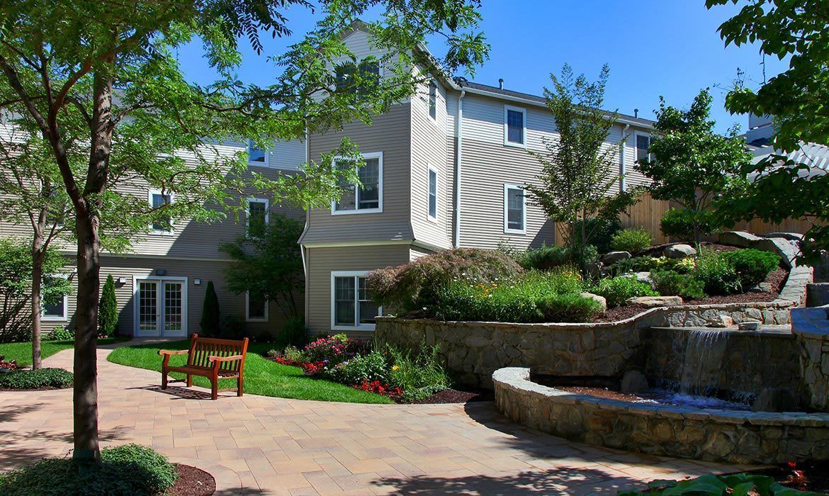 A well-maintained garden with a landscaped walkway in front of a modern building.