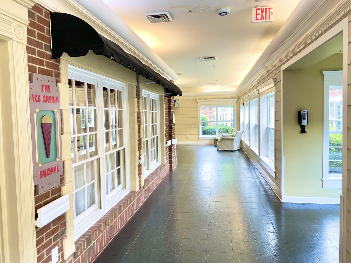 A bright hallway with large windows and brick walls, letting in natural light.