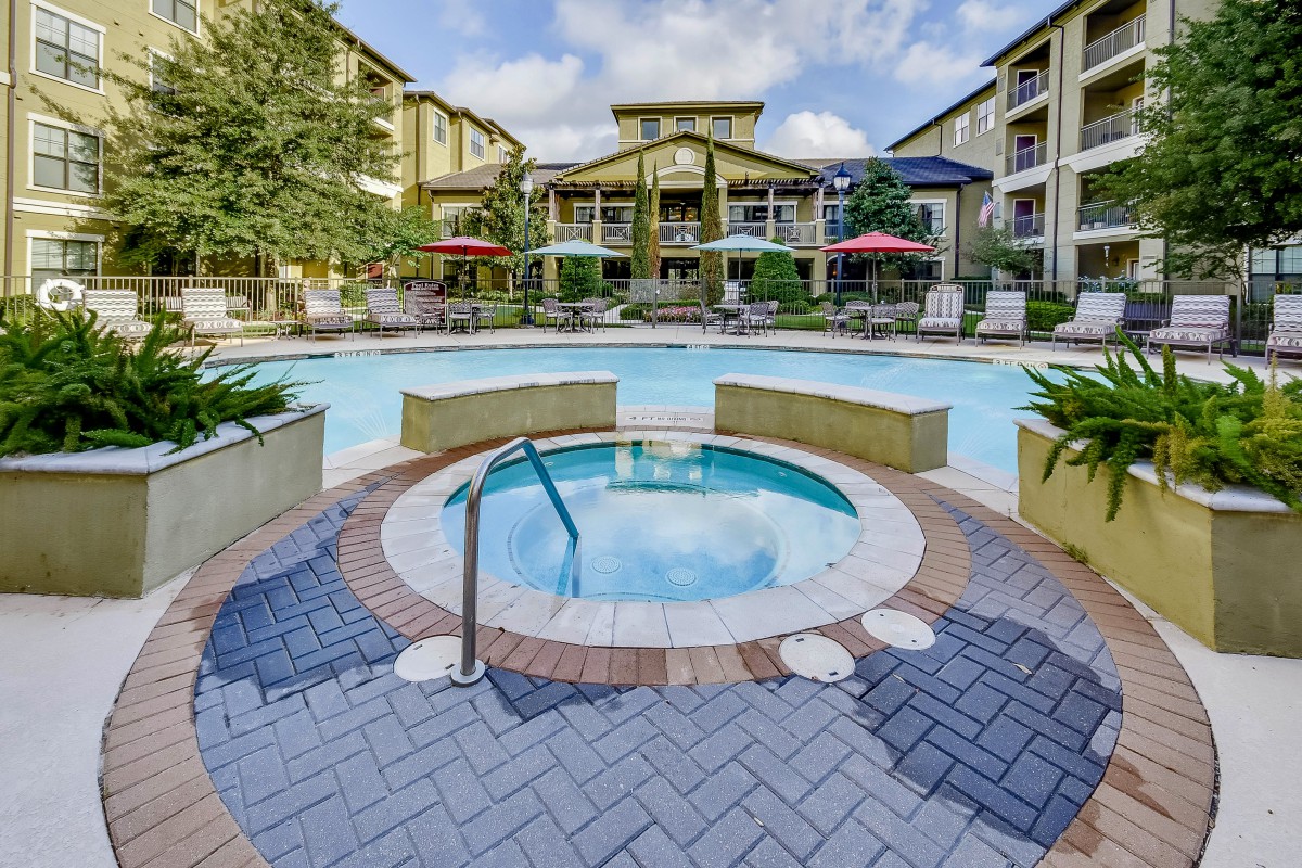 Luxurious outdoor area featuring a swimming pool and hot tub surrounded by resort-style accommodations.