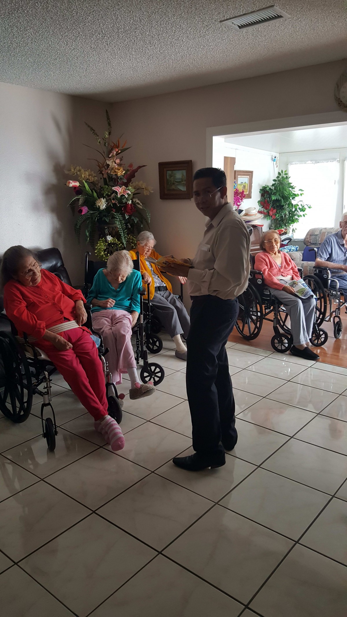 A caregiver interacting with elderly residents in a care home.