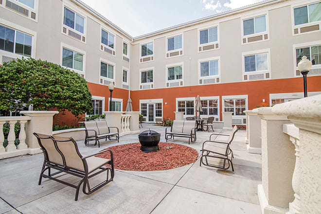 A well-furnished outdoor courtyard with a fire pit and seating arrangement.