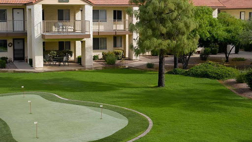 A serene view of a residential complex adjacent to a well-maintained golf course.