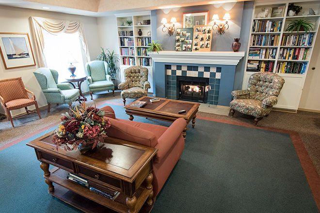 A cozy living room with a fireplace, bookshelves, and comfortable seating.