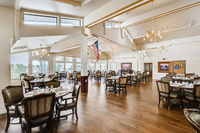 Elegant dining area with chandeliers, large windows, and American flag decor.