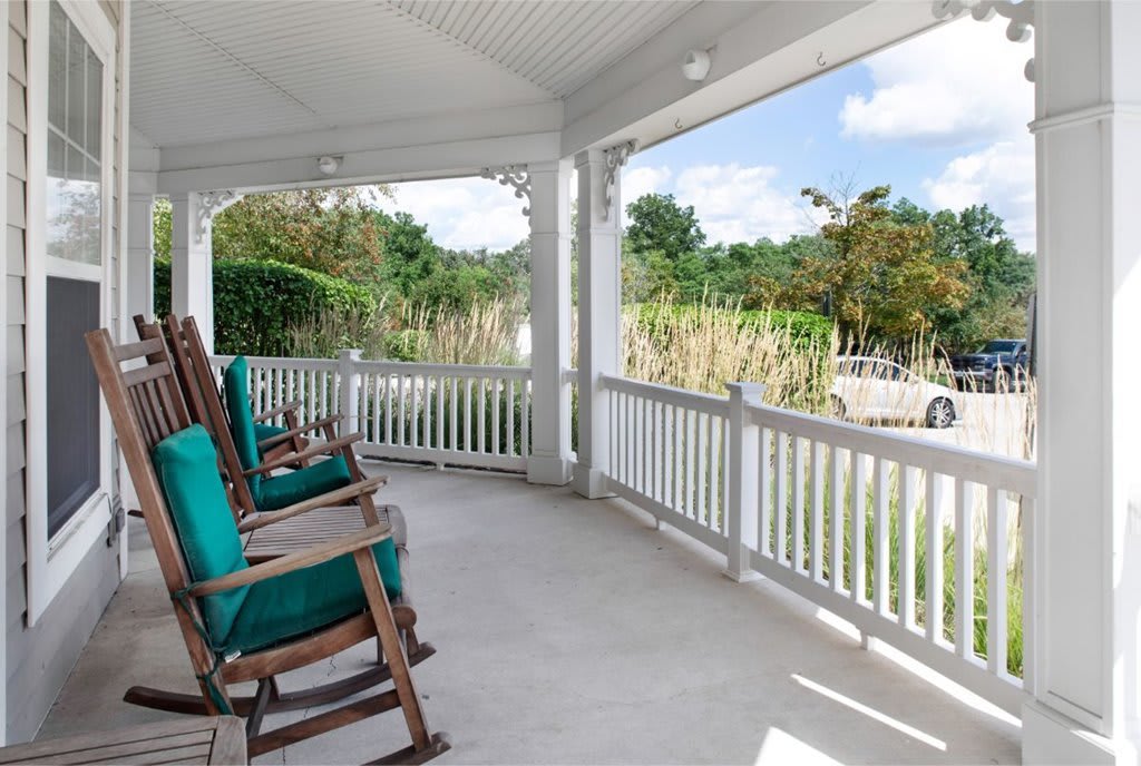 A tranquil porch with rocking chairs overlooking a scenic view.